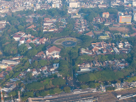 Aerial view of Alun Alun Malang surrounded by lush trees historic buildings and urban streets in the city center of Malang East Java Indonesia.
