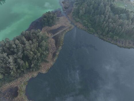 Aerial view of the volcanic lakes in the Dieng plateau featuring lush forest and contrasting water colors in Kejajar Central Java Indonesia. Aerial view of the volcanic lakes in the Dieng plateau featuring lush forest and contrasting water colors in Kejajar Central Java Indonesia.
