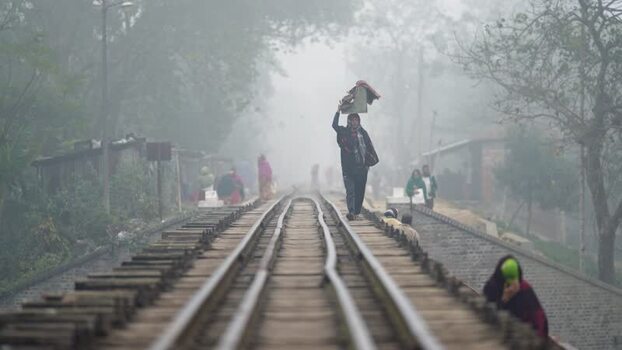 View of a man walking on a railway track in the fog Bangladesh. View of a man walking on a railway track in the fog Bangladesh.