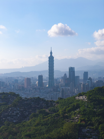 Aerial view of Taipei 101 rising above the city skyline with surrounding mountains and lush green hills in Taipei City Taiwan. Aerial view of Taipei 101 rising above the city skyline with surrounding mountains and lush green hills in Taipei City Taiwan.