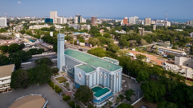 Aerial view of Holy Spirit Cathedral with its distinctive blue facade and green roof surrounded by urban greenery and city buildings in Accra Greater Accra Region Ghana. Aerial view of Holy Spirit Cathedral with its distinctive blue facade and green roof surrounded by urban greenery and city buildings in Accra Greater Accra Region Ghana.
