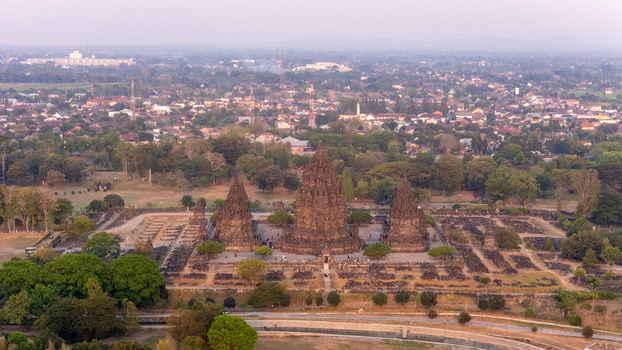 Aerial view of the historic Prambanan Temple complex with towering stone spires intricate carvings and lush greenery in Kecamatan Prambanan Daerah Istimewa Yogya Indonesia.