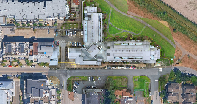 Aerial view of a building complex featuring parking lots and surrounding roads in Richmond British Columbia Canada. Aerial view of a building complex featuring parking lots and surrounding roads in Richmond British Columbia Canada.