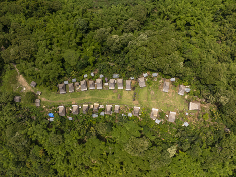 Aerial view of Kampung Adat Belaraghi featuring traditional thatched roof houses arranged in rows amidst lush tropical forest in Kecamatan Aimere Nusa Tenggara Timur Indonesia. Aerial view of Kampung Adat Belaraghi featuring traditional thatched roof houses arranged in rows amidst lush tropical forest in Kecamatan Aimere Nusa Tenggara Timur Indonesia.