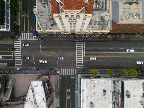 Aerial view of the Hollywood Walk of Fame with busy traffic on the intersection historic buildings and palm trees in Los Angeles California United States.