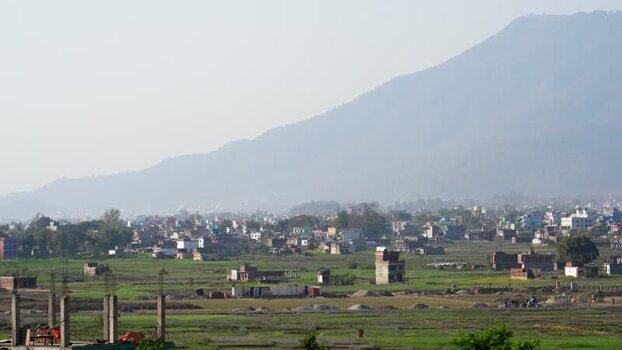 View of a town and green fields at the foot of a mountain Nepal.
