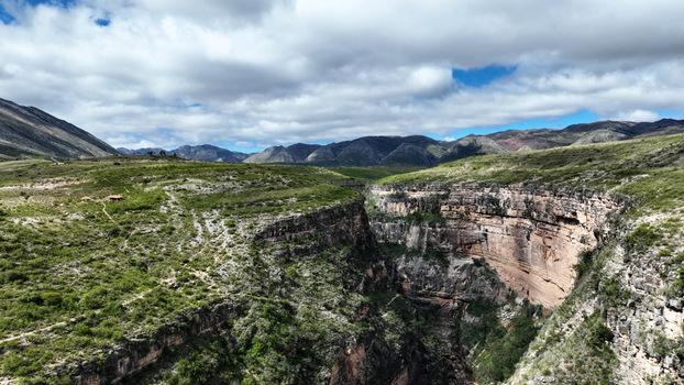 Aerial view of El Vergel canyon featuring steep rocky cliffs lush green vegetation and distant mountain ranges under a cloudy sky in Torotoro Potosi Department Bolivia. Aerial view of El Vergel canyon featuring steep rocky cliffs lush green vegetation and distant mountain ranges under a cloudy sky in Torotoro Potosi Department Bolivia.