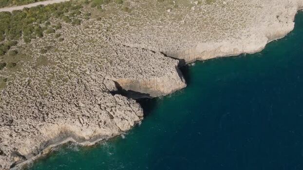 Aerial view of the rocky cliffs and turquoise sea of Plemmirio Italy.
