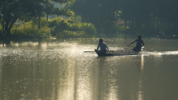 View of fishermen in a wooden boat on a river Bangladesh. View of fishermen in a wooden boat on a river Bangladesh.