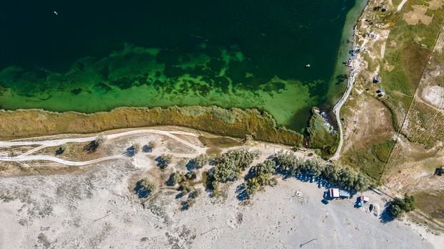 Aerial view of Blind Lake Sarfaranga Shigar featuring turquoise waters sandy desert dunes shoreline vegetation and dirt paths in Skardu Gilgit Pakistan. Aerial view of Blind Lake Sarfaranga Shigar featuring turquoise waters sandy desert dunes shoreline vegetation and dirt paths in Skardu Gilgit Pakistan.