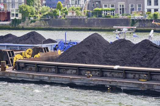 Dordrecht Netherlands 31 May 2026 View of a barge loaded with piles of coal navigating the Oude Maas river highlighting industrial trade and bulk transport in the Netherlands.