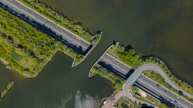 Aerial view of Aquaduct Veluwemeer with cars driving through the tunnel under the canal surrounded by green trees and calm water Harderwijk Gelderland Netherlands. Aerial view of Aquaduct Veluwemeer with cars driving through the tunnel under the canal surrounded by green trees and calm water Harderwijk Gelderland Netherlands.