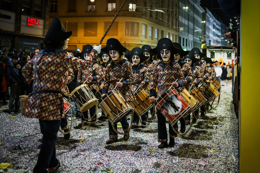 Basel Switzerland 10 March 2025 View of a vibrant parade of drummers their painted faces stark against the colorful confetti strewn street during Fasnacht. Basel Switzerland 10 March 2025 View of a vibrant parade of drummers their painted faces stark against the colorful confetti strewn street during Fasnacht.