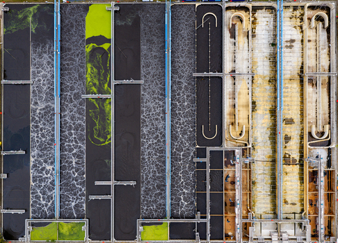 Aerial view of the Klarwerk Ruhleben wastewater treatment plant featuring aeration tanks with bubbling water and industrial infrastructure in Berlin Berlin Germany.