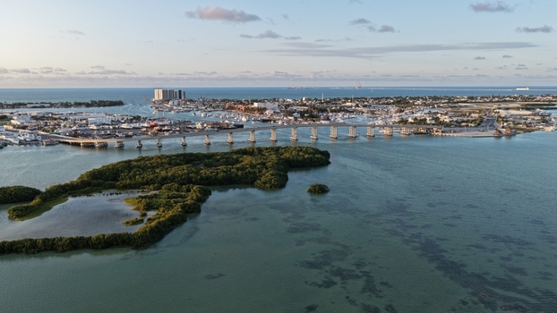 Aerial view of the Yucalpeten bridge spanning over the turquoise lagoon waters with lush mangroves and the coastal skyline under a soft sky Progreso Yucatan Mexico. Aerial view of the Yucalpeten bridge spanning over the turquoise lagoon waters with lush mangroves and the coastal skyline under a soft sky Progreso Yucatan Mexico.