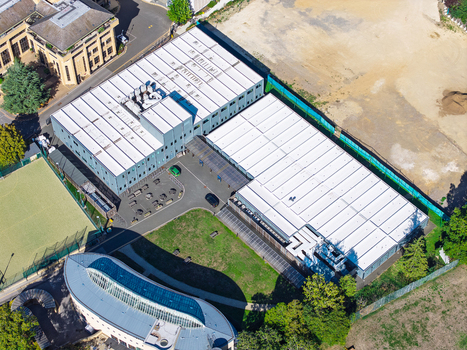 Aerial view of the Data Center at Oxford University showing the large white roofed industrial buildings surrounding green spaces and nearby modern architecture in Oxford England United Kingdom. Aerial view of the Data Center at Oxford University showing the large white roofed industrial buildings surrounding green spaces and nearby modern architecture in Oxford England United Kingdom.