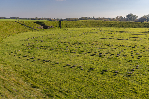 View of The Viking Fortress Trelleborg with its grassy ramparts and stone foundations of ancient longhouses in the green landscape of Slagelse Sjaelland Denmark. View of The Viking Fortress Trelleborg with its grassy ramparts and stone foundations of ancient longhouses in the green landscape of Slagelse Sjaelland Denmark.