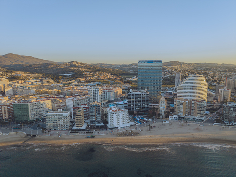 Aerial view of high rise apartment buildings hotels sandy beaches and the Mediterranean Sea along the coastline in Calp Valencian Community Spain. Aerial view of high rise apartment buildings hotels sandy beaches and the Mediterranean Sea along the coastline in Calp Valencian Community Spain.