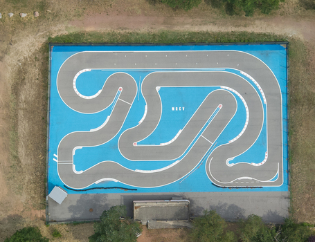 Aerial view of an RC car track with a blue surface and asphalt racing lines surrounded by grass and trees in Commelle Vernay Auvergne Rhone Alpes France. Aerial view of an RC car track with a blue surface and asphalt racing lines surrounded by grass and trees in Commelle Vernay Auvergne Rhone Alpes France.