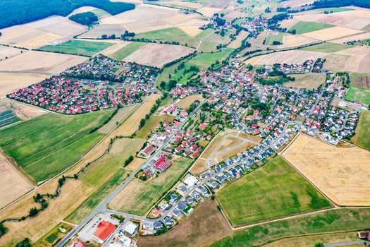 Aerial view of the village of Munchaurach with its traditional red roofed houses winding stream and vast agricultural fields under bright daylight Aurachtal Bayern Germany. Aerial view of the village of Munchaurach with its traditional red roofed houses winding stream and vast agricultural fields under bright daylight Aurachtal Bayern Germany.
