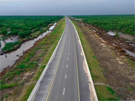 Aerial view of a long asphalt road stretching through the lush mangrove forests and wetlands of Bonny Island Bonny Town Rivers Nigeria. Aerial view of a long asphalt road stretching through the lush mangrove forests and wetlands of Bonny Island Bonny Town Rivers Nigeria.