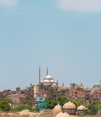 View of the Mosque of Muhammad Ali at the Cairo Citadel with its domes and minarets rising above the urban landscape under a clear blue sky Cairo Egypt.