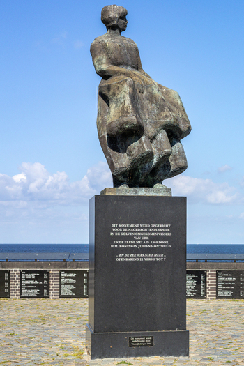 View of the Fisherman s Monument featuring a bronze statue of a woman looking out to sea on a sunny day in Urk Flevoland Netherlands. View of the Fisherman s Monument featuring a bronze statue of a woman looking out to sea on a sunny day in Urk Flevoland Netherlands.