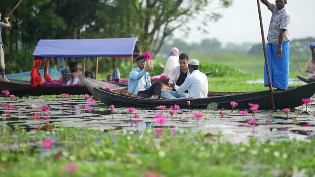 View of people on boats in a water lily pond Bangladesh. View of people on boats in a water lily pond Bangladesh.