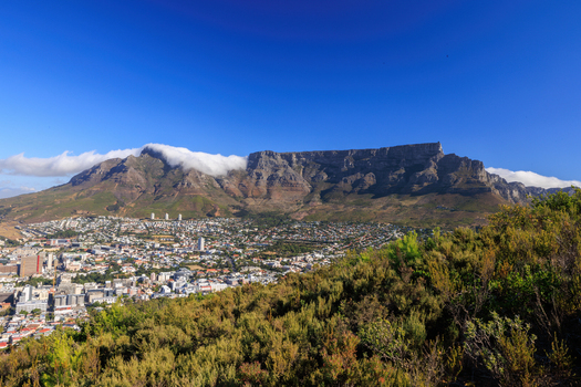 View of Table Mountain rises majestically a flat topped giant veiled in wispy clouds overlooking the sprawling city nestled below Cape Town Western Cape South Africa.