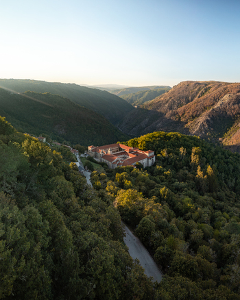 Aerial view of the Monastery of Santo Estevo de Ribas de Sil nestled in the lush forests of the Ribeira Sacra valley at sunset O Covelo Ourense Spain. Aerial view of the Monastery of Santo Estevo de Ribas de Sil nestled in the lush forests of the Ribeira Sacra valley at sunset O Covelo Ourense Spain.