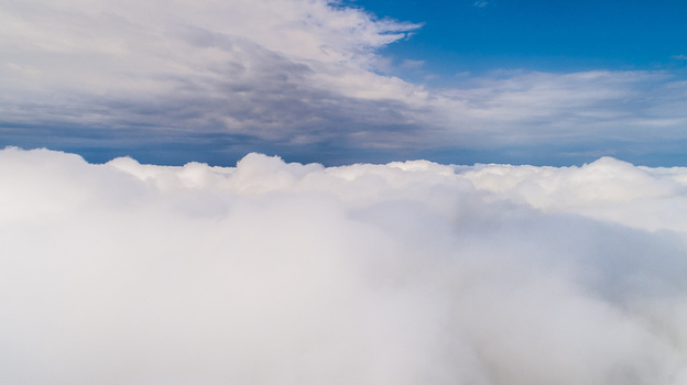 Aerial view of a vast expanse of white clouds under a bright blue sky in Latvia. Aerial view of a vast expanse of white clouds under a bright blue sky in Latvia.