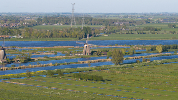 Aerial view of traditional windmills along water canals and green polder fields Kinderdijk South Holland Netherlands. Aerial view of traditional windmills along water canals and green polder fields Kinderdijk South Holland Netherlands.