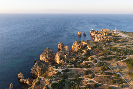 Aerial view of the dramatic limestone cliffs and rock formations of Ponta da Piedade with winding coastal paths and the Atlantic Ocean in Lagos Faro District Portugal.