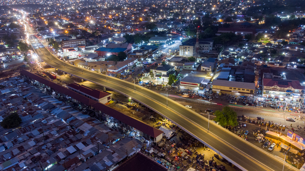 Tamale Ghana 16 March 2023 Aerial view of the illuminated Tamale Interchange at night with surrounding urban buildings busy roads and residential rooftops.