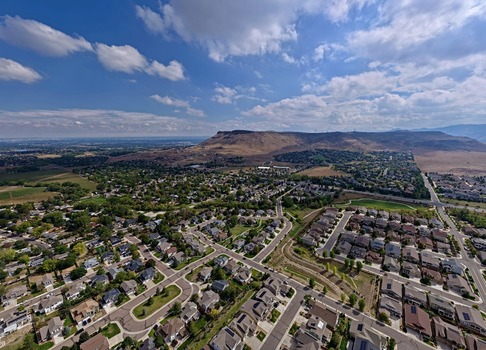 Aerial view of the residential neighborhoods of Golden Colorado with North Table Mountain in the background under a blue sky with scattered clouds. Golden Colorado United States.