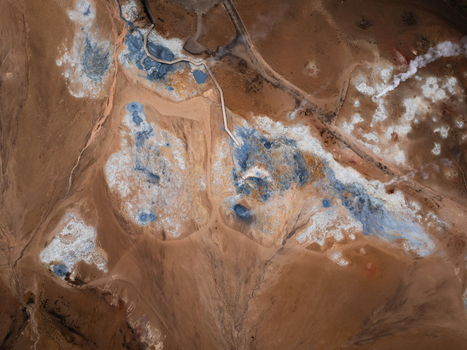 Aerial view of Hverir geothermal area with bubbling mud pools steaming fumaroles and colorful mineral deposits surrounded by volcanic terrain in Reykjahlid Thingeyjarsveit Iceland. Aerial view of Hverir geothermal area with bubbling mud pools steaming fumaroles and colorful mineral deposits surrounded by volcanic terrain in Reykjahlid Thingeyjarsveit Iceland.