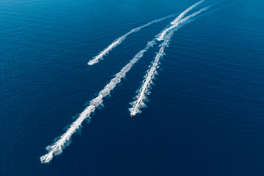 Aerial view of speedboats leaving white wakes on the deep blue Mediterranean Sea near Le Trayas in Saint Raphael Provence Alpes Cote d Azur France. Aerial view of speedboats leaving white wakes on the deep blue Mediterranean Sea near Le Trayas in Saint Raphael Provence Alpes Cote d Azur France.