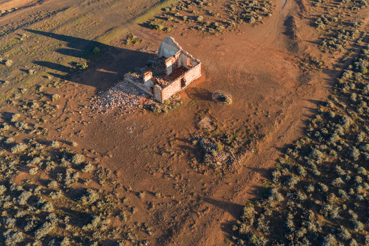 Aerial view of stone ruins of an old building in the arid desert landscape with sparse vegetation and long shadows Flinders Ranges South Australia Australia. Aerial view of stone ruins of an old building in the arid desert landscape with sparse vegetation and long shadows Flinders Ranges South Australia Australia.