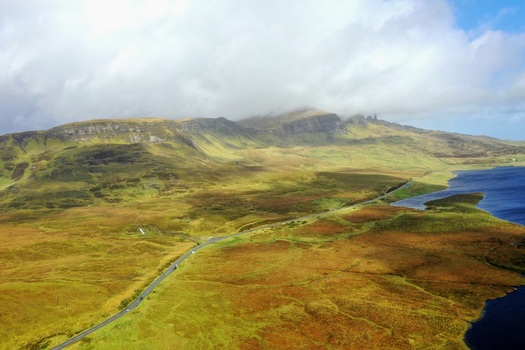 Aerial view of The Storr with its dramatic rocky cliffs and grassy slopes under a cloudy sky Portree Scotland United Kingdom.
