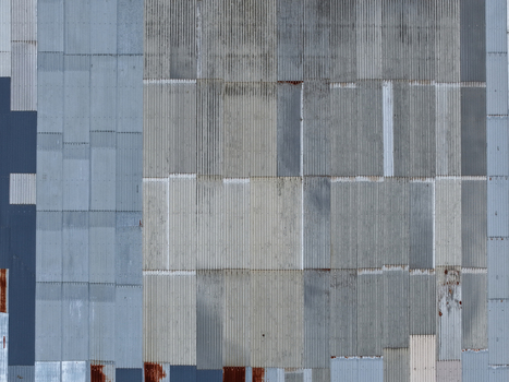 Melbourne VIC Australia 25 September 2026 Aerial view of corrugated metal panels on an industrial building roof showing weathered textures rust spots and overlapping steel sheets.