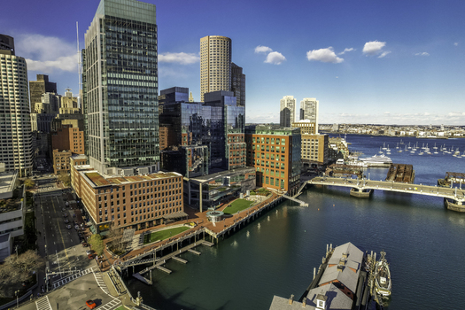 Aerial view of glassy skyscrapers reflecting the clear blue sky contrasting with the red brick buildings lining the waterfront Boston Massachusetts United States.