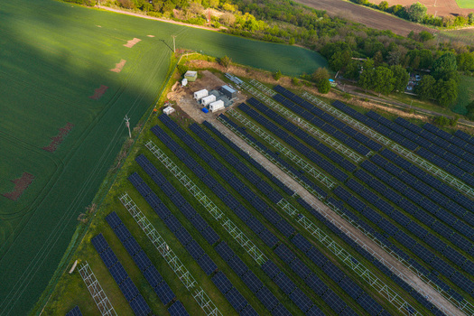 Aerial view of FVE Bohumilice solar farm with rows of photovoltaic panels adjacent to lush green fields in Klobouky u Brna Jihomoravsky kraj Czechia. Aerial view of FVE Bohumilice solar farm with rows of photovoltaic panels adjacent to lush green fields in Klobouky u Brna Jihomoravsky kraj Czechia.