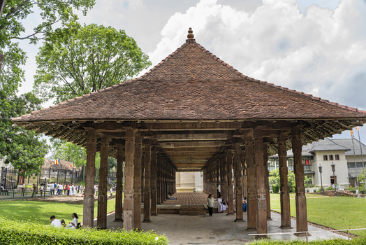 Kandy Sri Lanka 27 April 2026 View of Sri Dalada Maligawa featuring its traditional wooden pillared hall with a tiled roof set within the temple grounds with people walking nearby. Kandy Sri Lanka 27 April 2026 View of Sri Dalada Maligawa featuring its traditional wooden pillared hall with a tiled roof set within the temple grounds with people walking nearby.