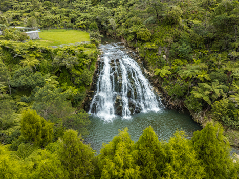 Aerial view of a majestic waterfall cascading into a serene pool surrounded by lush green foliage and trees a hidden oasis of natural beauty Waikino Waikato Region New Zealand. Aerial view of a majestic waterfall cascading into a serene pool surrounded by lush green foliage and trees a hidden oasis of natural beauty Waikino Waikato Region New Zealand.