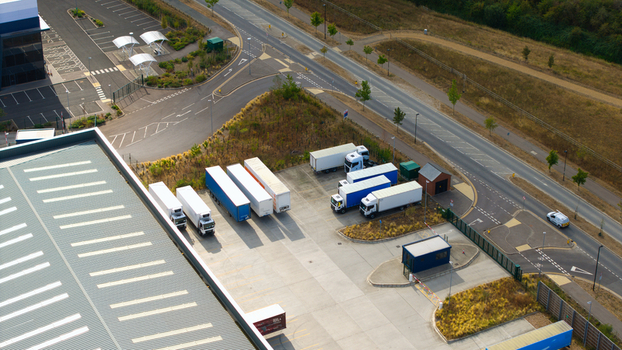 Aerial view of a logistics hub featuring industrial warehouses and multiple parked HGVs and semi trailers in Bedford England United Kingdom. Aerial view of a logistics hub featuring industrial warehouses and multiple parked HGVs and semi trailers in Bedford England United Kingdom.