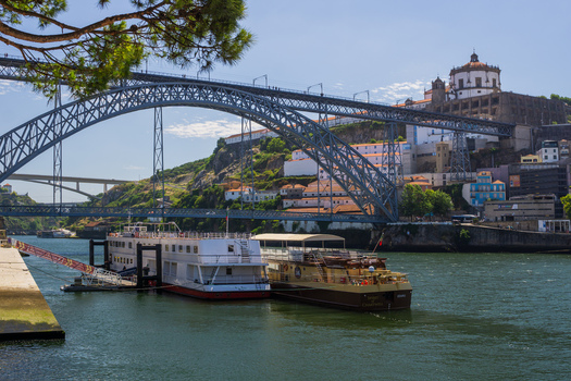 Aerial view of the iconic Dom Luís I Bridge stretching across the Douro River with boats docked along the waterfront Porto Porto District Portugal. Aerial view of the iconic Dom Luís I Bridge stretching across the Douro River with boats docked along the waterfront Porto Porto District Portugal.