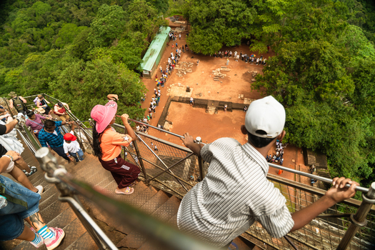 Sri Lanka 21 February 2026 View of tourists climbing the metal stairs of Sigiriya rock fortress overlooking ancient ruins and lush green jungle.