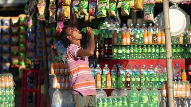 View of a man drinking at a street stall Bangladesh. View of a man drinking at a street stall Bangladesh.