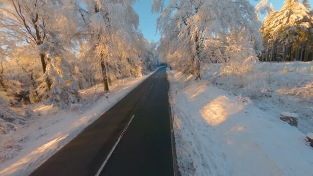 FPV aerial view of snow covered road in Germany.