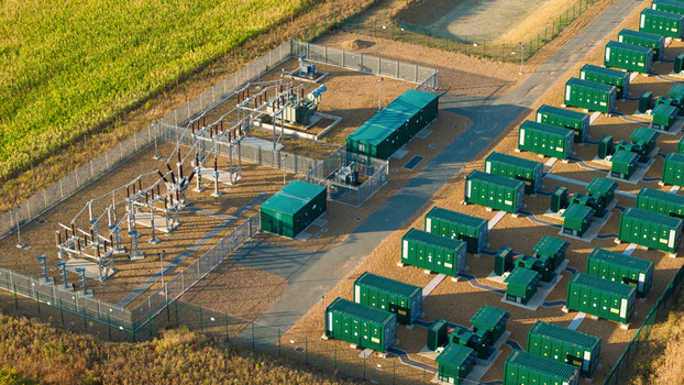 Aerial view of the Battery Energy Storage System at BESS Grendon with rows of green battery containers electrical transformers and security fencing in Northampton England United Kingdom. Aerial view of the Battery Energy Storage System at BESS Grendon with rows of green battery containers electrical transformers and security fencing in Northampton England United Kingdom.